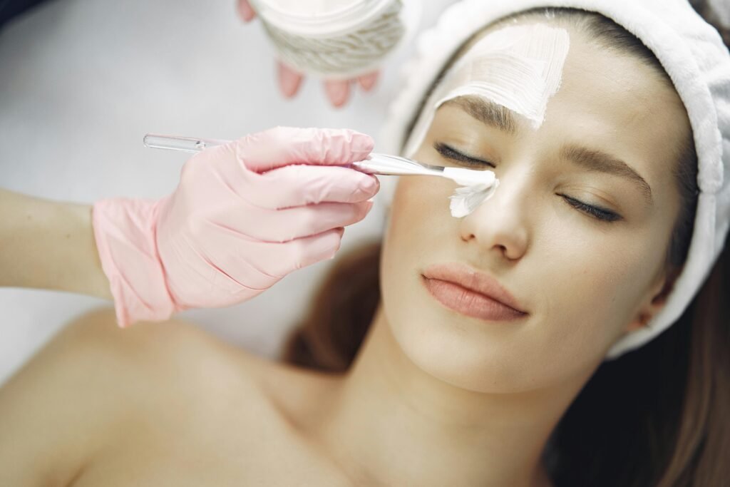 Close-up of a woman receiving a relaxing facial treatment with a skincare mask indoors.