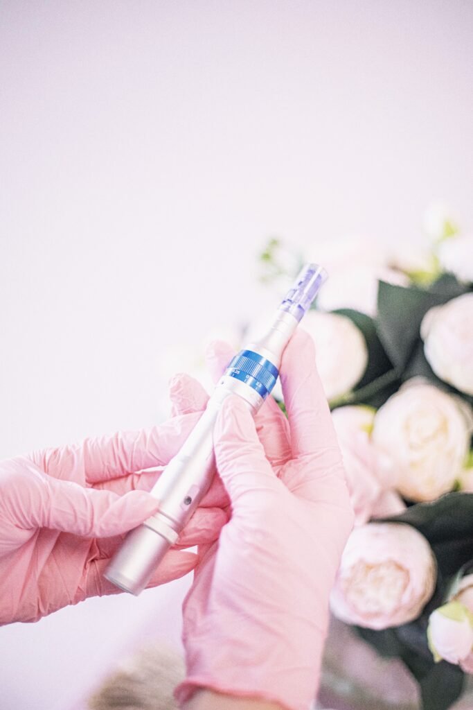 Close-up of hands holding a micro-needling pen, highlighting its use in modern aesthetic treatments.