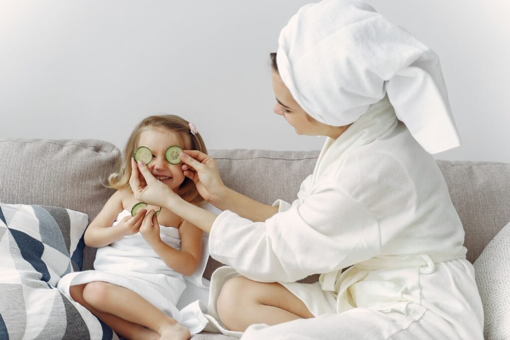A mother and daughter enjoy a relaxing spa day at home with cucumbers and laughter.